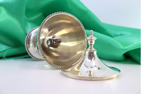 Bomboneira em prata lisa cordeada na envolvência com pomo na tampa e base frisada.