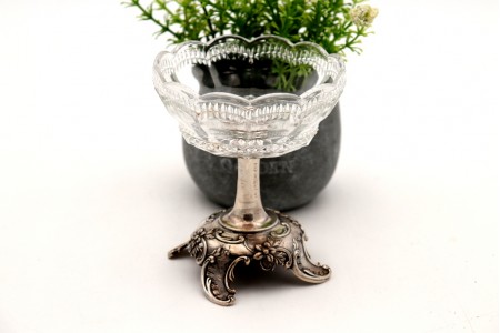 Bomboneira em vidro lapidado assente em base de prata com relevos florais e quatro pés 