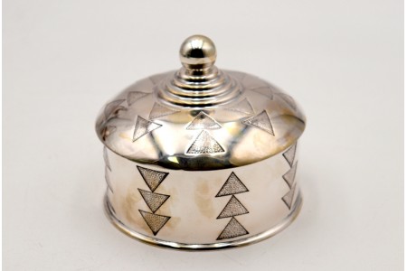 Bomboneira em prata redonda com relevos em forma de triângulos e pomo na tampa frisada