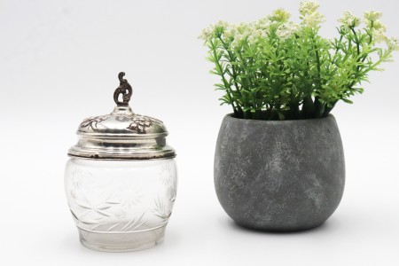 Bomboneira em vidro lapidado a ácido com tampa de prata decorada com motivos florais em alto relevo e pomo recortado.