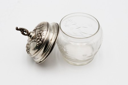 Bomboneira em vidro lapidado a ácido com tampa de prata decorada com motivos florais em alto relevo e pomo recortado.