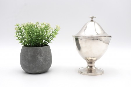 Bomboneira em prata lisa com base circular e aplicação de pomo em flor na tampa 