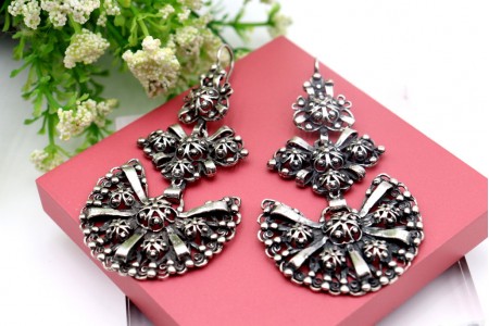 Brincos em prata com relevos, aplicações e bombolinas oscilantes.