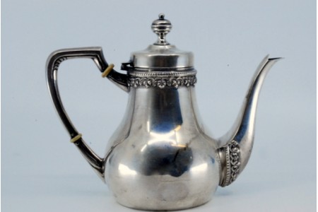 Chaleira em prata lisa com frisos no rebordo e bico, pega relevada e pomo na tampa.