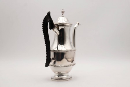 Cafeteira de prata frisos perlados envolventes,  asa em madeira de castanho e base em formato elíptico.