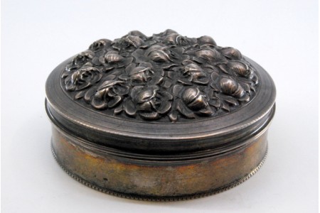 Caixa em prata com flores relevas na tampa e friso perlado.