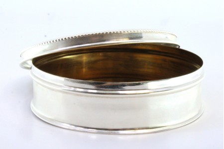 Caixa em prata lisa de forma circular e perlada na tampa amovível.