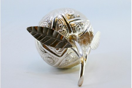 Caixa de prata em forma de fruta com gravados e aplicações nas duas folhas.