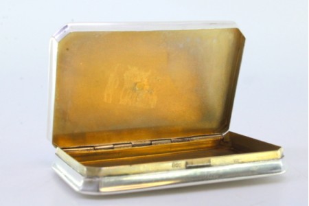 Caixa de rapé em prata envolvendo cartela relevada com motivos campestres, tampa basculante e interior dourado