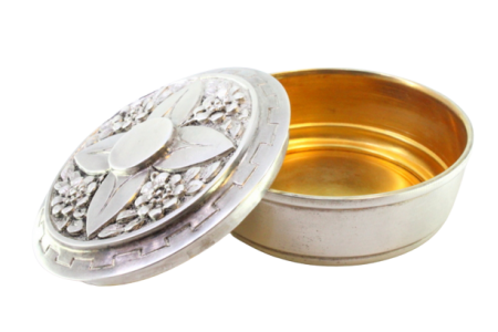 Caixa em prata para hóstias com motivos florais relevados na tampa e interior dourado.