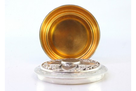 Caixa em prata para hóstias com motivos florais relevados na tampa e interior dourado.