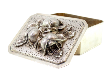 Caixa em prata com flores em alto relevo na tampa amovível e interior dourado.