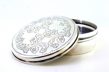 Caixa em prata de forma circular com relevos vegetalistas na tampa 
