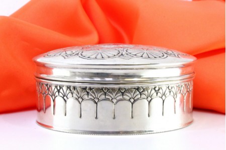  Caixa em prata com círculos concêntricos revelados na tampa amovível.