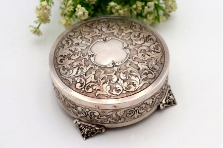 Caixa em prata em formato circular com relevos e cartela para monograma