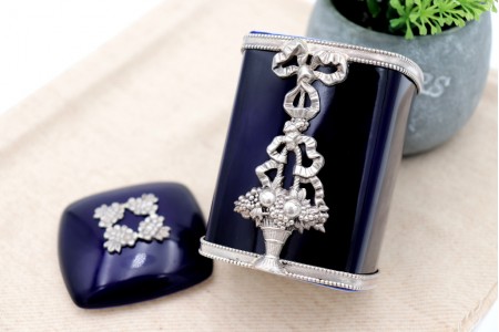  Caixa em porcelana azul com aplicações em prata com frisos perlados, laços e boquet de flores da marca Topázio.