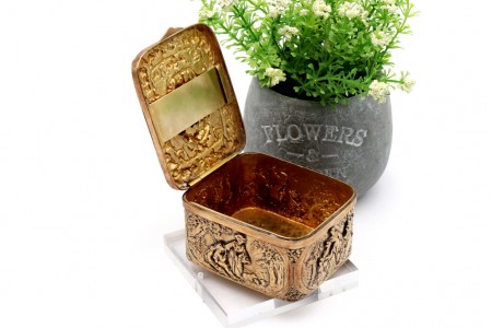 Caixa em prata em prata dourada com casal em momento idílico no centro