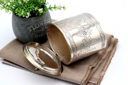 Caixa para chá em prata com motivos florais gravados envolvendo cartela para monograma frisos na envolvência e pomo na tampa