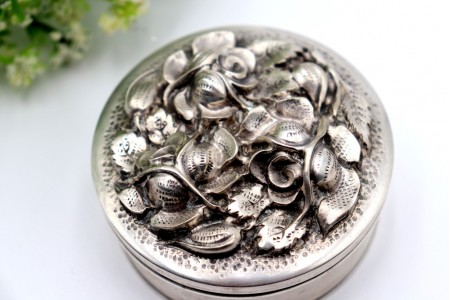 Caixa em prata circular com motivos florais revelados na tampa