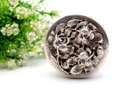 Caixa em prata circular com motivos florais revelados na tampa