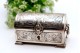 Guarda joias em prata em forma de baú com gravados e duas pegas