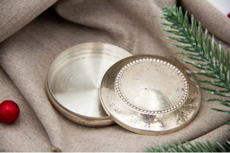 Caixa de prata para terço de formato circular com friso perlado e figura de nau gravada.