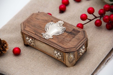 Caixa para selos em pau santo com aplicações em prata relevada e assente em quatro pés.