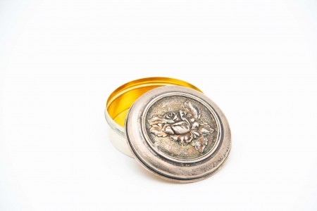 Caixa em prata de forma circular com relevos de rosa na tampa