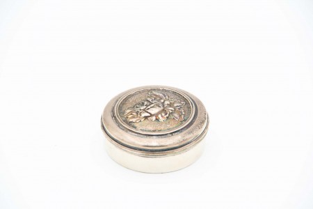 Caixa em prata de forma circular com relevos de rosa na tampa