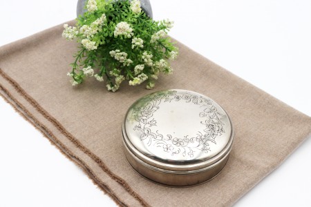 Caixa guarda-jóias em prata de forma circular com gravados de flores