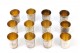 Conjunto de doze copos pra vodka em prata com relevos florais envolvendo cartelas para monogramas e interior em dourado.