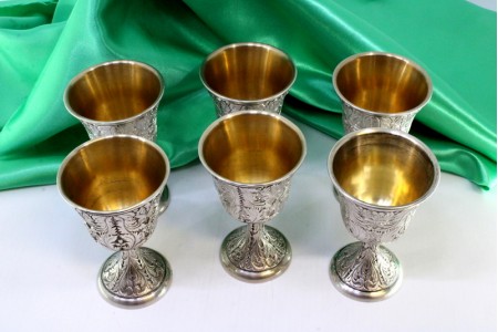 Conjunto de seis cálices em prata com relevos cinzelados e interior em dourado.