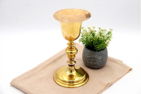 Cálice com patena em prata dourada com fuste torneado e assente sobre base frisada em formato circular.