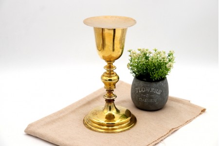 Cálice com patena em prata dourada com fuste torneado e assente sobre base frisada em formato circular.