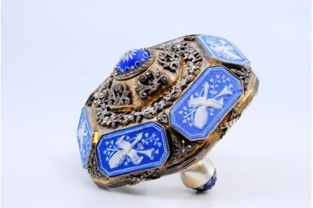 Campainha de mesa para abertura em prata com aplicações de mosaicos relevados e assente sobre três pés em forma de meia bola.