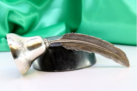 Campainha em prata com relevos e pomo em forma de pena em vulto perfeito.