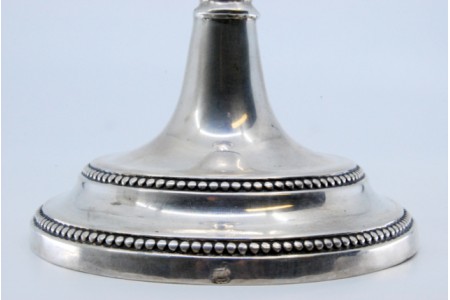 Castiçal solitário em prata lisa com frisos no fuste e na base circular.