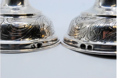 Castiçais em prata com motivos florais gravados nas arandelas, fustes e nas bases circulares