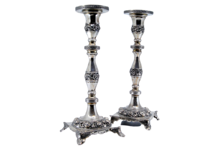 Castiçais em prata com fustes torneados e motivos florais relevados, base assente sobre quatro pés.