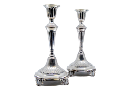 Castiçais em prata com caneluras assentes sobre bases circulares com quatro pés recortados.