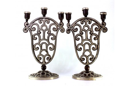 Candelabros de três lumes em pau santo com revestimento em prata recortada e assentes em bases circulares.