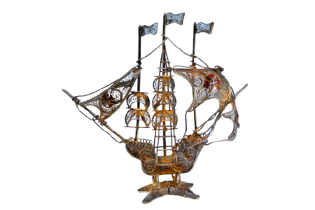 Caravela em  prata filigrana com cruzes esmaltadas nas velas e mastros, assente sobre base recortada.