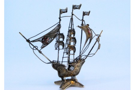 Caravela em  prata de filigrana com cruzes nas velas e mastros, assente em base recortada.