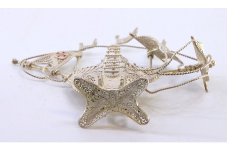 Caravela pequena em prata de filigrana com cruzes esmaltadas nas velas e assente em base com quatro pés.