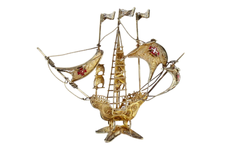 Caravela em prata filigrana dourada com cruzes esmaltadas nas velas e mastro assente sobre base recortada dividida em quatro.