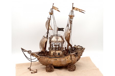 Porta garrafas em prata revelada em forma de caravela com relevos e aplicações