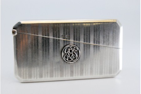  Cartoneira em prata guilhochada com bandas ao alto e tampa basculante.