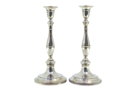 Castiçais em prata com os fustes lisos assentes em bases circulares com frisos perlados.