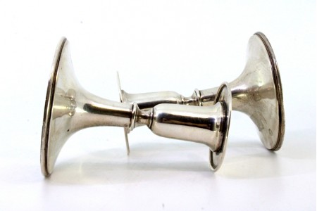 Conjunto de castiçais baixos em prata lisa com frisos nas bases circulares.