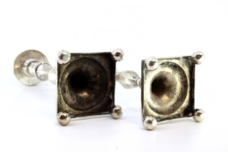 Conjunto de castiçais em prata com fustes relevados e frisos, assentes em bases 